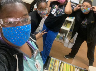 Clincians pose for a picture wearing masks and eye protection.